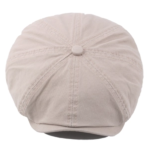 Béret classique beige en coton avec coutures à huit panneaux et bouton sur fond blanc