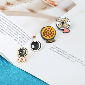 Cartoon enamel pin set with bomb, medal, globe and electric fan designs on a book