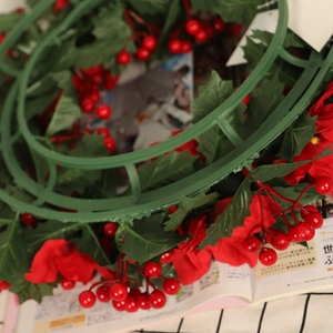 Christmas wreath with red berries, silk flowers and green leaves on plastic base