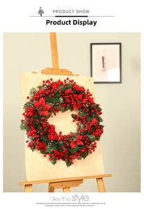 Detail of Christmas wreath with red berries, poinsettias and green holly leaves on wood