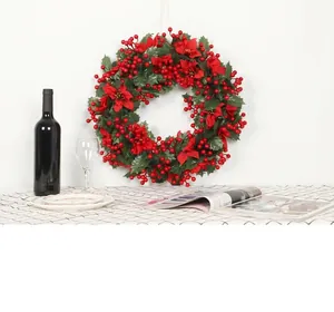Detail of Christmas wreath with red poinsettia flowers and artificial holly berries