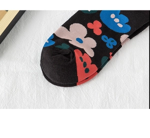 Close-up of black cotton crew socks with colorful floral patterns on the toe area