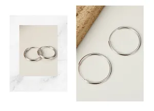 Polished S925 sterling silver hoop earrings in various sizes on minimalist stone props
