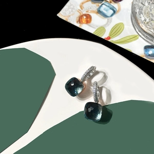 Detail of square navy blue crystal earrings with micro-pave silver hoops set on geometric backdrop