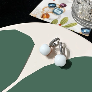 Detailed close-up of a silver earring with a white square crystal and pavé zircon stones