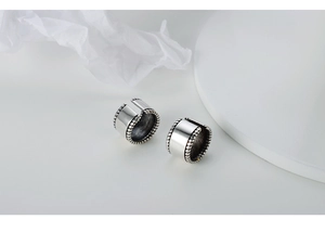 Macro detail of S925 sterling silver ear cuffs with twisted edges and polished finish