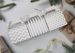 Close-up of three gray-white Halloween gift boxes with stripes and wave patterns