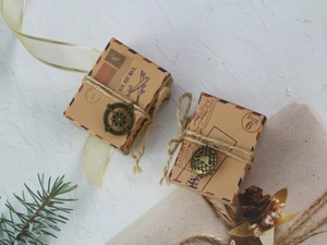 Macro detail of vintage kraft paper candy box with air mail prints and metal compass charm