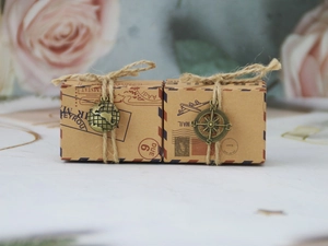 Close-up of vintage kraft airmail gift boxes with compass charms and hemp rope