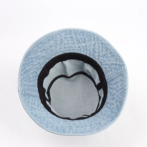 Detail view of denim sun hat interior featuring a black cotton sweatband and fine stitching