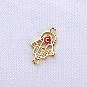 Detail of gold Hamsa hand charm with devil's eye and zircons for DIY jewelry making