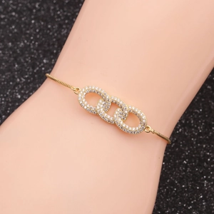 Detail of infinity triple interlocking rings bracelet with white cubic zirconia on gold chain