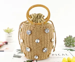 Close-up of handmade straw bucket bag with rhinestone accents and drawstring lining