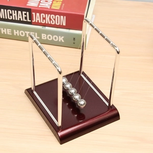 Newton's cradle with silver metal balls on a dark wood base for physics desk decor