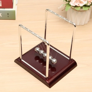 Top view of metal Newton's cradle balls on a dark red wood base for office desktop decor