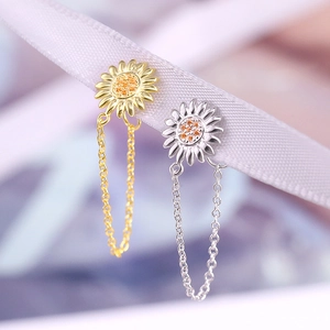 Macro shot of silver sunflower earrings with sparkling center stones and tassels