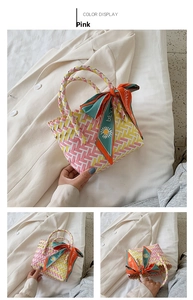Detail of pink hand-woven straw bag with colorful floral silk scarf and braided texture