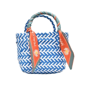 Blue and white woven basket handbag with a patterned silk scarf handle for summer beach