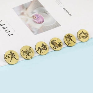 Detailed view of vintage bronze zodiac pins with relief carvings of Libra and Scorpio