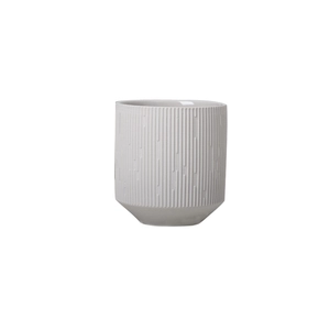 Dettaglio di un contenitore per candela in ceramica bianca con strisce verticali e finitura opaca