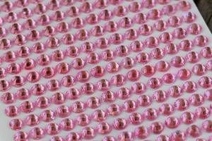 Macro detail of 3mm pink acrylic rhinestone stickers for DIY crafts and decorations