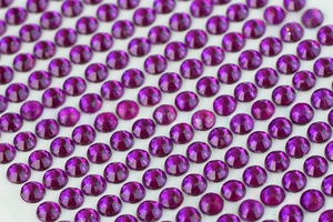 Macro shot of 3mm dark purple faceted acrylic rhinestones for DIY crafts and nail art