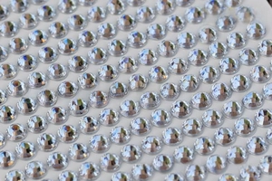 Macro shot of 3mm clear white round rhinestones in a dense matrix for DIY craft projects