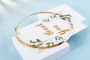 Detailed view of a polished gold minimalist choker necklace on a geometric display stand