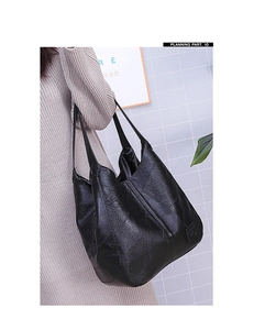 Detail der schwarzen Shopper-Tasche aus genarbtem Leder mit Patchwork-Design und Gurt