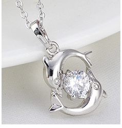 Macro shot of silver dolphin pendant necklace with large round white zircon crystal