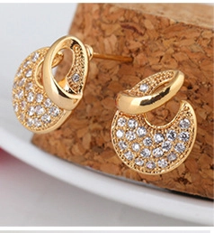 Macro shot of 18K gold plated semi-circular stud earrings with sparkling white zircons