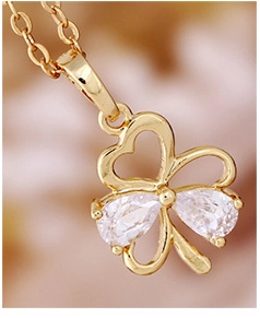Macro shot of clover pendant necklace with pear-cut zircon and 18K gold plating
