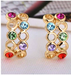 Macro detail of 18K gold plated hoop earrings with multicolored sparkling cubic zirconia