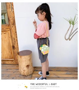 Girl wearing a cute yellow and green mushroom-shaped crossbody bag in a natural setting