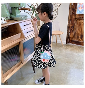 Child model wearing a mushroom-shaped crossbody bag with blue polka dot cap and pink base