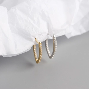 Close-up of V-shaped S925 sterling silver hoop earrings with inset crystals in gold and silver