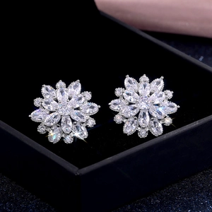 Macro shot of luxury sunflower cubic zirconia stud earrings in a black velvet jewelry box