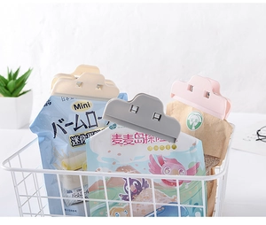 Detail of multi-colored plastic food clips sealing snacks in a white basket setting