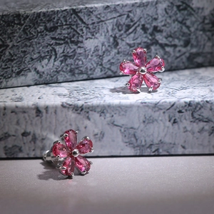 Detail of flower-shaped stud earrings with rose pink zirconia petals and silver base