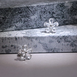 Close-up of zircon-inlaid five-petal flower stud earrings with polished silver finish
