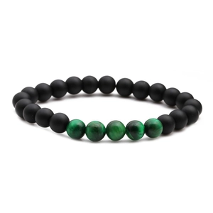 Close-up of matte black beads and green tiger eye stones on a beaded bracelet