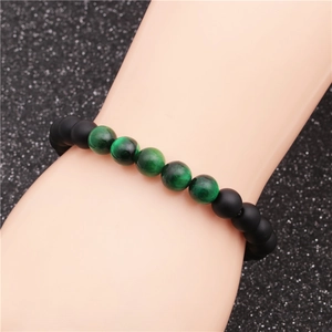 Detailed macro view of matte black and green tiger eye beads on 8mm stretch bracelet