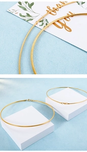 Details goldener Schlangenketten mit Karabinerverschluss auf blauem Hintergrund mit Blöcken
