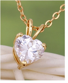 Macro detail of heart-cut zircon pendant with 18K gold-plated four-prong setting