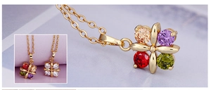 Macro detail of four-leaf clover pendant necklace with multi-color zircon stones