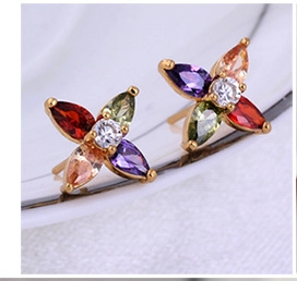 Macro shot of 18K gold plated flower earrings with colorful zircon petals on ceramic