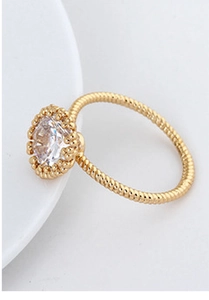 Detailed view of gold plated twisted rope ring with a large sparkling round zircon inlay