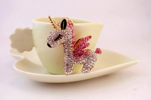 Detailed close-up of a gold unicorn keychain with pink and clear crystals and bead charms