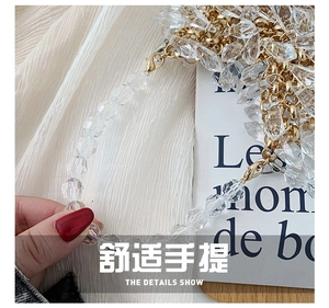 Detail of handmade clear crystal beaded evening bag with golden chain and lobster clasp