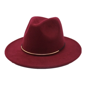 Detail of burgundy wool fedora hat featuring a black cord and gold metal tube band